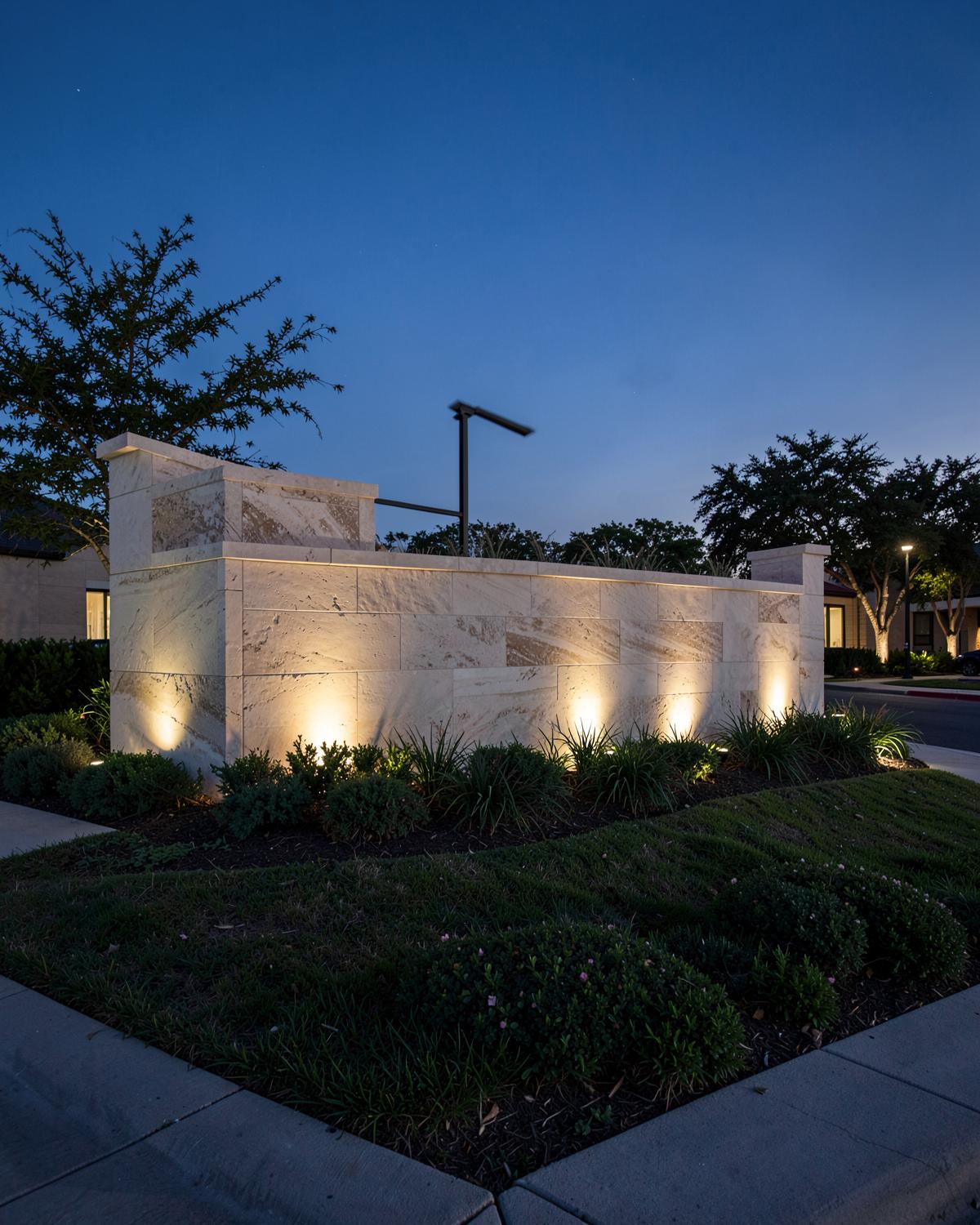 Stone monument entrance to a master-planned community in Texas at dusk